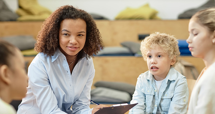 Smiling Black Woman Listening To Children in Support Group